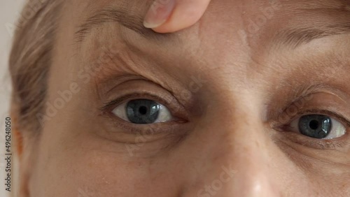 Close-up of a mature woman's eyes, she is frustrated with wrinkles on her forehead between the eyebrows