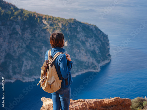 Butterfly Valley (kelebekler vadisi) in city of Oludeniz Fethiye in western Turkey. You can only reach this valley by boat or rock climbing. woman looks down on sea from cliff. photo