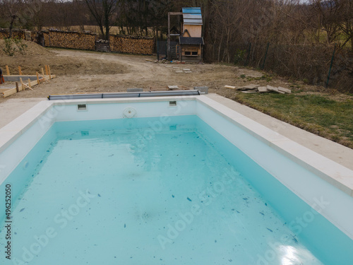 Aerial view of pool construction site with stone border in a garden all not finished yet