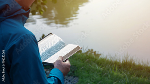 Fotografie, Obraz Man Reading Bible By Lake