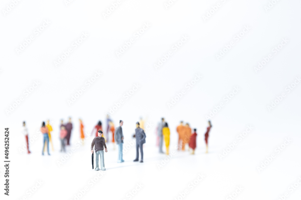 Miniature old man leaving a group pf young prople. Concept of transition of new generation people. Miniature old man leaving a group pf young prople. Concept of transition of new generation people.