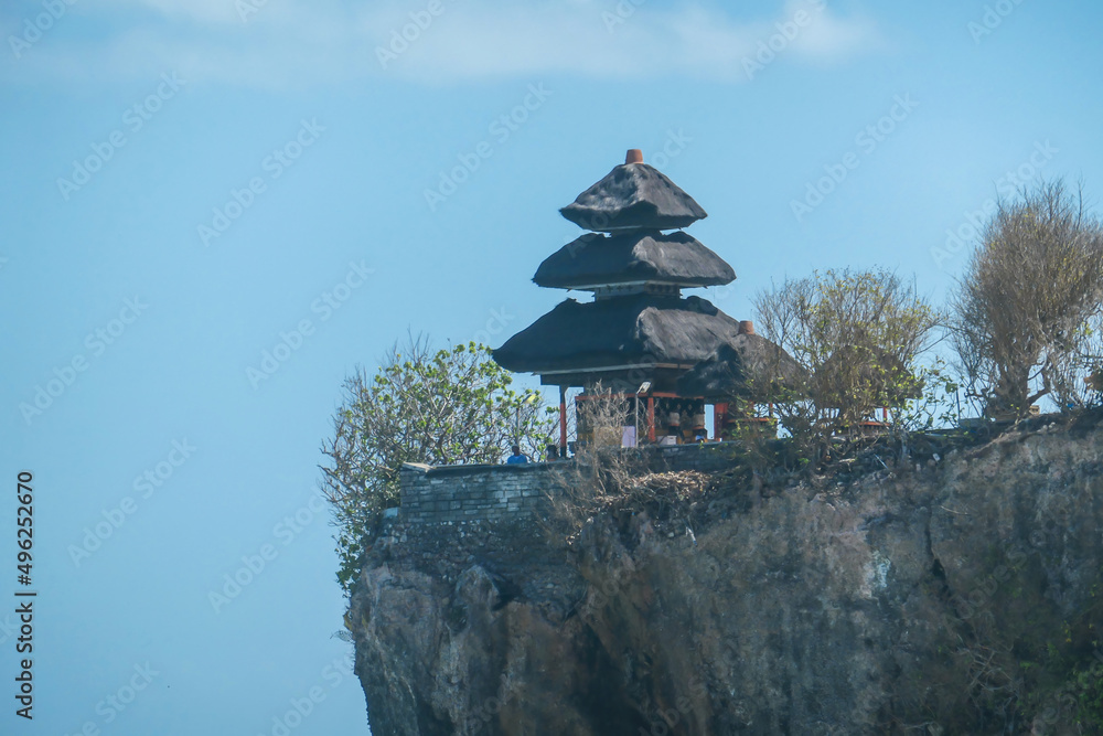 A view on Uluwatu Cliffs, Bali, Indonesia. There is a small temple on the top of the cliff. The waves are rushing to the shore, making the water bubbly. Steep and dangerous fall. Hidden gem A view on Uluwatu Cliffs, Bali, Indonesia. There is a small temple on the top of the cliff. The waves are rushing to the shore, making the water bubbly. Steep and dangerous fall. Hidden gem
