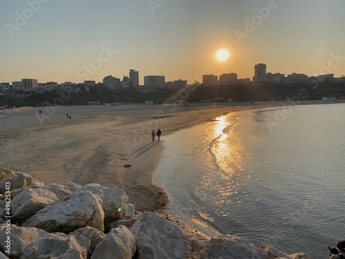 Couple walking on the beach at sunset photo