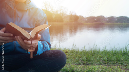 Fotografie, Obraz Man Reading Bible By Lake in the morning