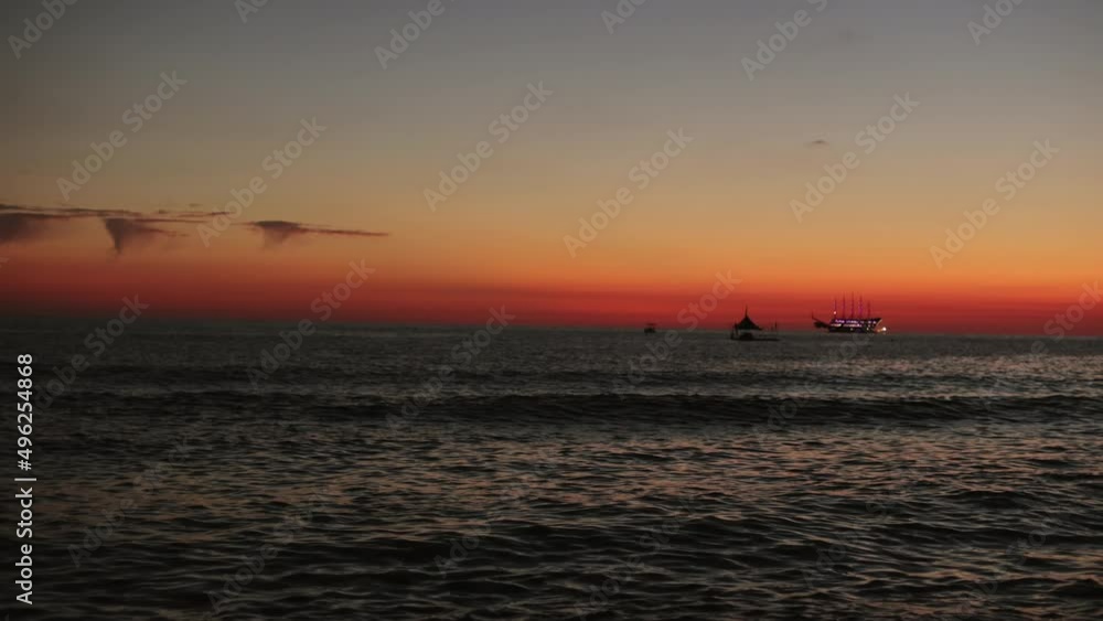 Beautiful summer sunset over sea with floating boats in distance. Evening sunlight, traveling, holiday and vacation concept. Beautiful summer sunset over sea with floating boats in distance. Evening sunlight, traveling, holiday and vacation concept.
