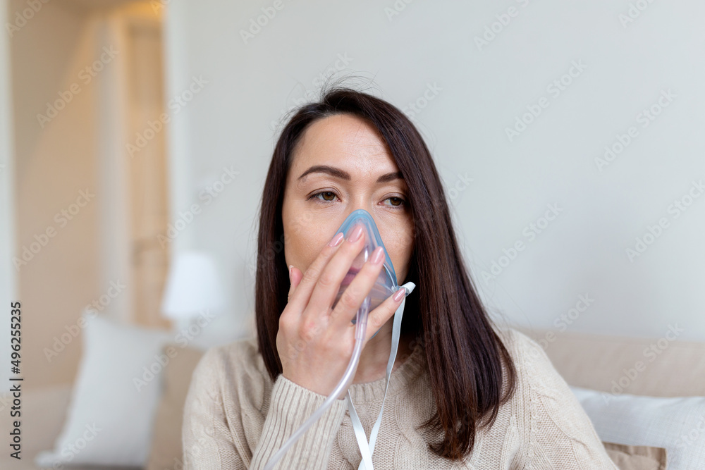 Sick Asian woman making inhalation, medicine is the best medicine. Ill woman wearing an oxygen mask and undergoing treatment for covid-19. woman with an inhaler Sick Asian woman making inhalation, medicine is the best medicine. Ill woman wearing an oxygen mask and undergoing treatment for covid-19. woman with an inhaler