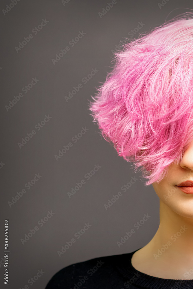 Beautiful young caucasian woman with short curly bob hairstyle dyed in pink color with closed eyes against dark gray background with copy space Beautiful young caucasian woman with short curly bob hairstyle dyed in pink color with closed eyes against dark gray background with copy space