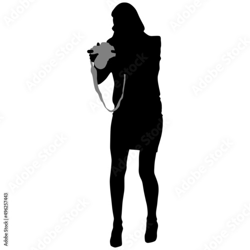 Black silhouette of slender woman in short skirt with camera in her hands
