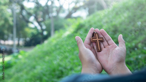 Man hands holding wooden cross photo