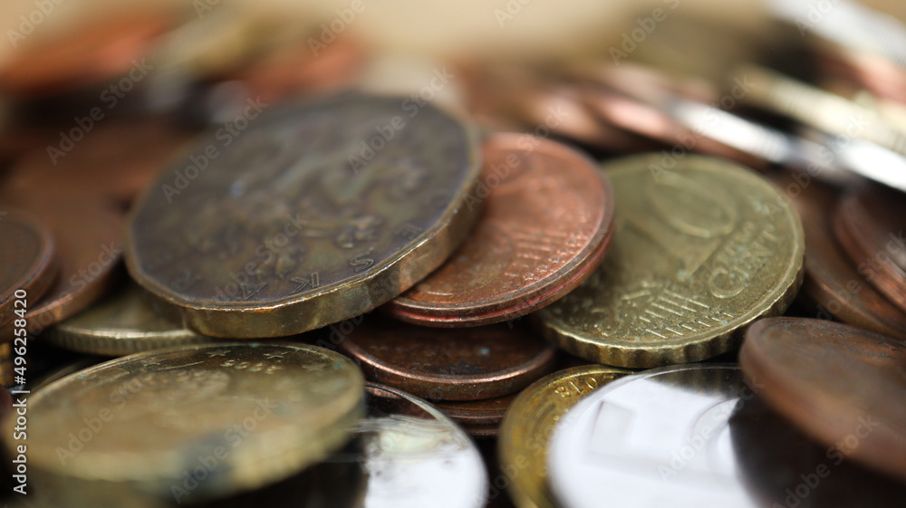 Macro shot of metal coins, different change spilled on platform, saving coin, selective focus Macro shot of metal coins, different change spilled on platform, saving coin, selective focus