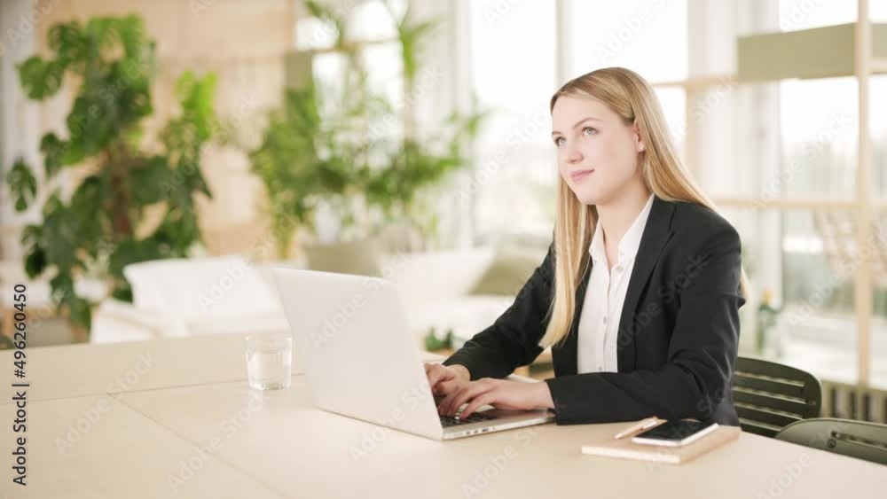 Young woman working on laptop sitting at desk Young woman working on laptop sitting at desk