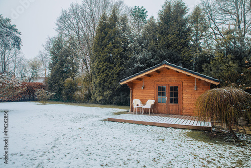 Nice wooden hut in a garden with snow. Garden shed with chairs in winter. Winter mood. Drinking tea outside by cold in winter.  snow in Germany. garden in winter. holiday house