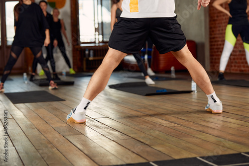 Large diverse group of people doing aerobics exercises in a class in a gym in a health and fitness concept