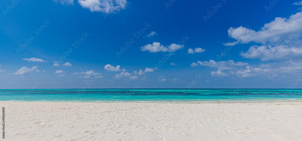 Fototapeta premium Closeup sandy beach waves and blue summer sky. Panoramic beach landscape. Empty tropical beach and seascape, horizon. Bright blue sky, soft sand, calmness, tranquil seaside relaxing sunlight, summer