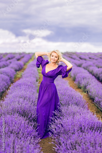 beautiful older woman in a long purple dress. An elderly woman in a field of lavender