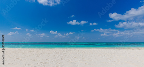 Fototapeta Naklejka Na Ścianę i Meble -  Closeup sandy beach waves and blue summer sky. Panoramic beach landscape. Empty tropical beach and seascape, horizon. Bright blue sky, soft sand, calmness, tranquil seaside relaxing sunlight, summer 