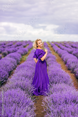 beautiful older woman in a long purple dress. An elderly woman in a field of lavender
