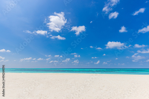 Closeup sandy beach waves and blue summer sky. Panoramic beach landscape. Empty tropical beach and seascape, horizon. Bright blue sky, soft sand, calmness, tranquil seaside relaxing sunlight, summer 