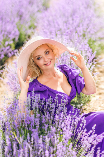 Close-up portrait of an elderly woman in a hat. A woman is sitting in a field of lavender.
