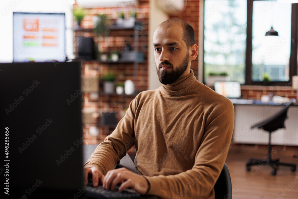 Office worker with financial knowledge seeking business recovery solution while using desktop PC. Marketing company employee sitting at desk, developing management plan while using work computer. Office worker with financial knowledge seeking business recovery solution while using desktop PC. Marketing company employee sitting at desk, developing management plan while using work computer.