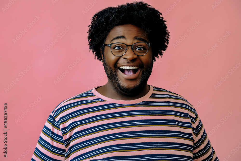 Obraz premium young happy african american man posing in the studio over pink background