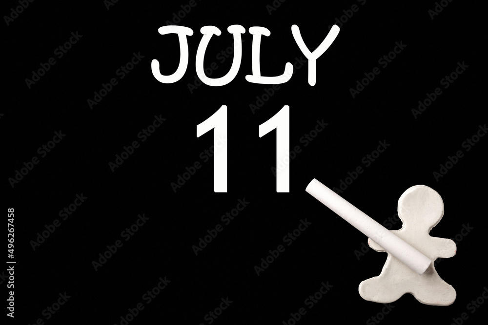 A small white plasticine man writing the date 11July on a black board. Business concept. Education concept. A small white plasticine man writing the date 11July on a black board. Business concept. Education concept.