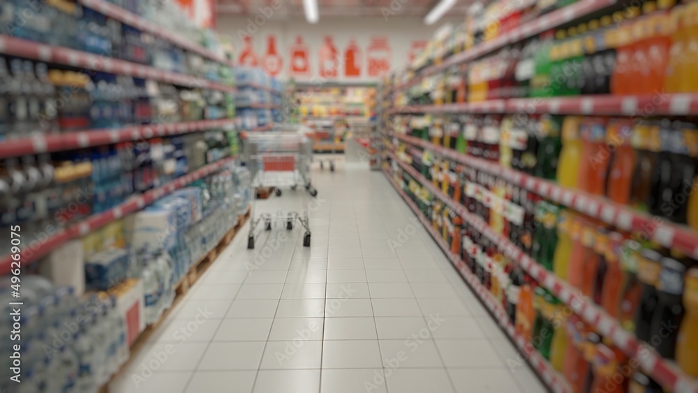 Blurry unfocused background of goods in the supermarket. Shelves with products. Food products. Food expenses. Background of the supermarket interior.