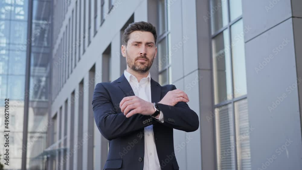 Portrait of a young successful businessman looking at camera posing. Serious business man standing outdoors. Confident look of a focused business man face emotion. Male crossed arms Successful people. Portrait of a young successful businessman looking at camera posing. Serious business man standing outdoors. Confident look of a focused business man face emotion. Male crossed arms Successful people.
