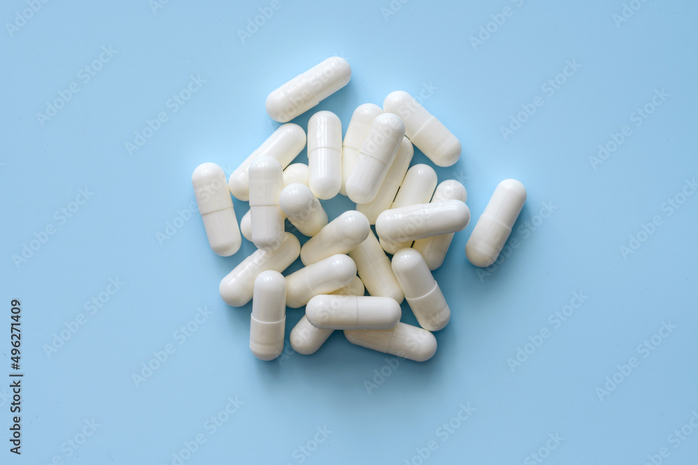 Bunch of white pills on a blue background Bunch of white pills on a blue background