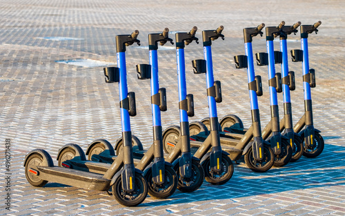 Eight blue electric scooters in a row are waiting for users. Modern urban eco-friendly transport photo