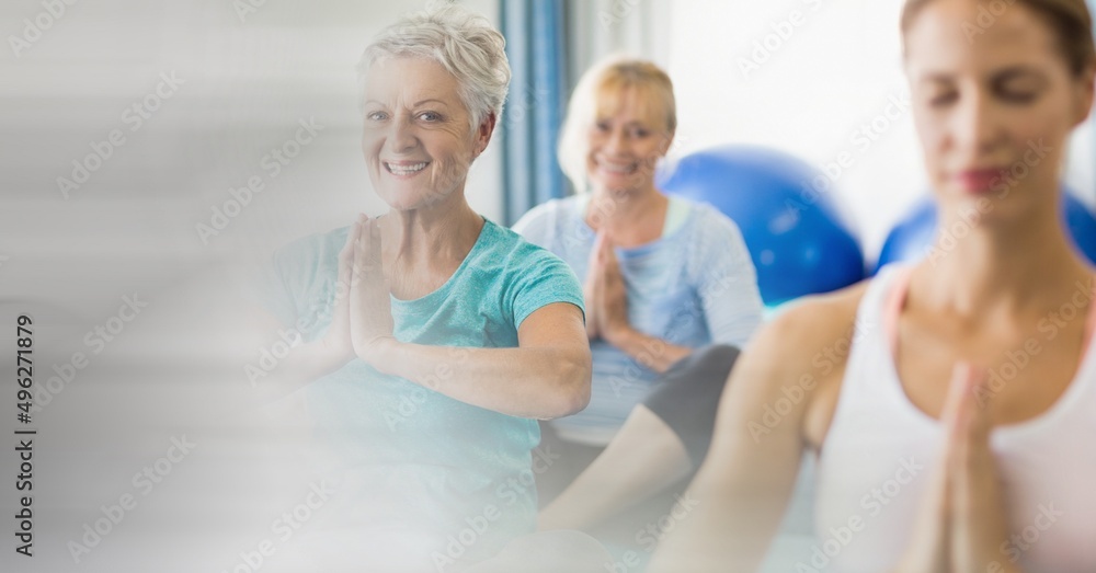 Blur effect with copy space against female yoga trainer and group of senior people performing yoga