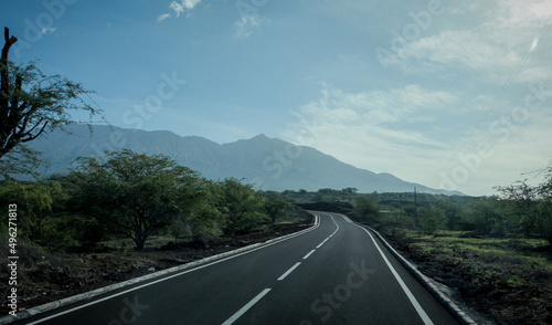 Long straight road leading to the hills of Fogo island on Cabo Verde towards the famous Volcano of Fogo on a sunny day.