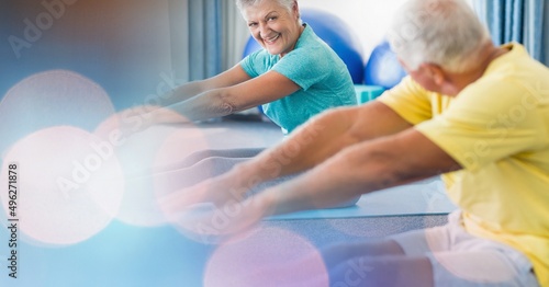 Blur effect with copy space against senior couple performing stretching exercise at retirement home