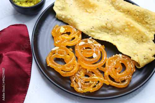 Popular Indian sweet Jalebi and Fafda served with Sambhara. Gujarati snack is mostly eaten during Indian Festivals such as, Gudi Padwa, Dussehra, Eid, Diwali, Mahashivratri, Holi. with Copy space.  photo