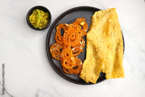 Popular Indian sweet Jalebi and Fafda served with Sambhara. Gujarati snack is mostly eaten during Indian Festivals such as, Gudi Padwa, Dussehra, Eid, Diwali, Mahashivratri, Holi. with Copy space.  photo