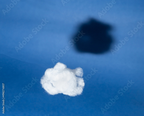 White cloud with black shadow on blue sky background. Comparison, reverse side of medal concept. Surrealism style. Hidden, invisible features. High quality photo photo