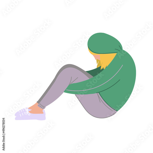 A depressed woman with puzzled thoughts in her mind. A young sad girl sits and unhappily hugs her knees.
