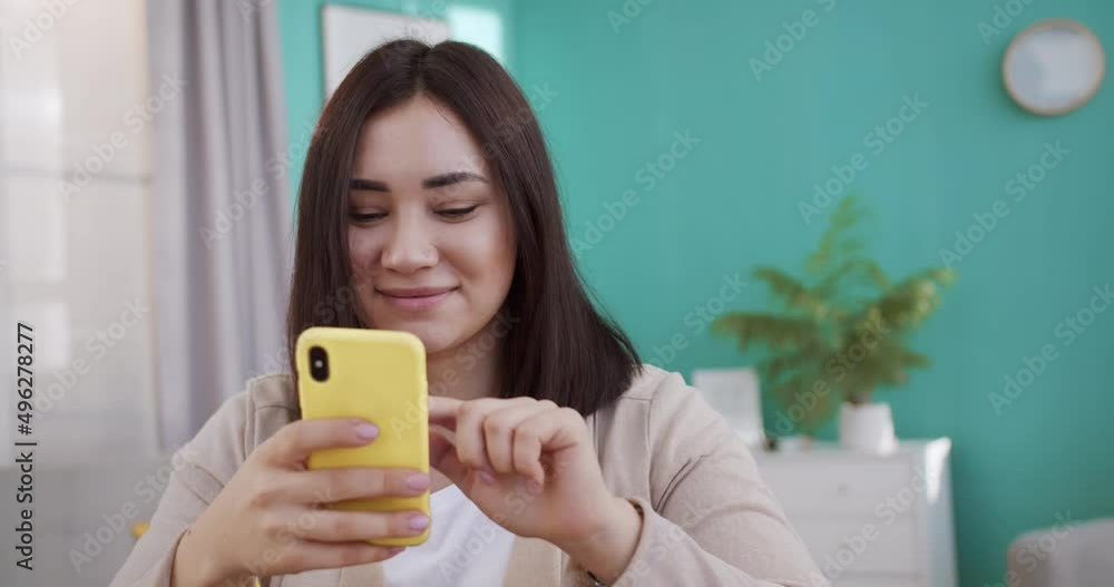 Woman use of smart phone for online shopping in social media platform and sit on sofa at home. Stay at home, epidemic, quarantine, pandemic Woman use of smart phone for online shopping in social media platform and sit on sofa at home. Stay at home, epidemic, quarantine, pandemic