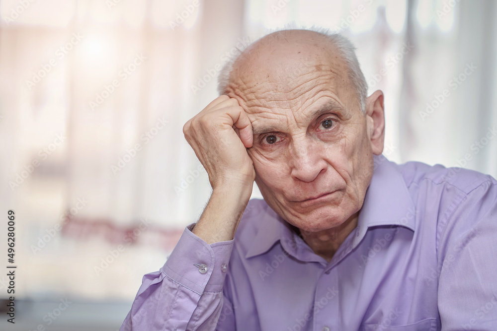 Senior pensive man sitting at table and holding gray haired head with hand. Oldness concept. Senior pensive man sitting at table and holding gray haired head with hand. Oldness concept.