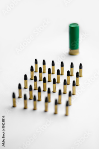 high angle view of bullets near blurred shotgun shell on white background.