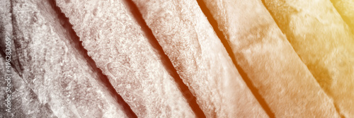 slices of white bread close up as a background. gray backdrop of rough textured surface chopped pieces loaf of natural organic food. top view. toned in black white color. banner. flare