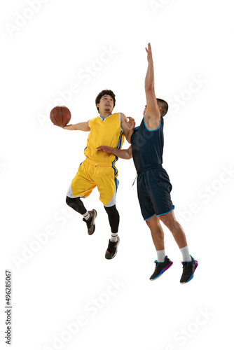 Full-length portrait of two young basketball players jumping with ball isolated on white studio background. Motion, activity, sport concepts. © master1305