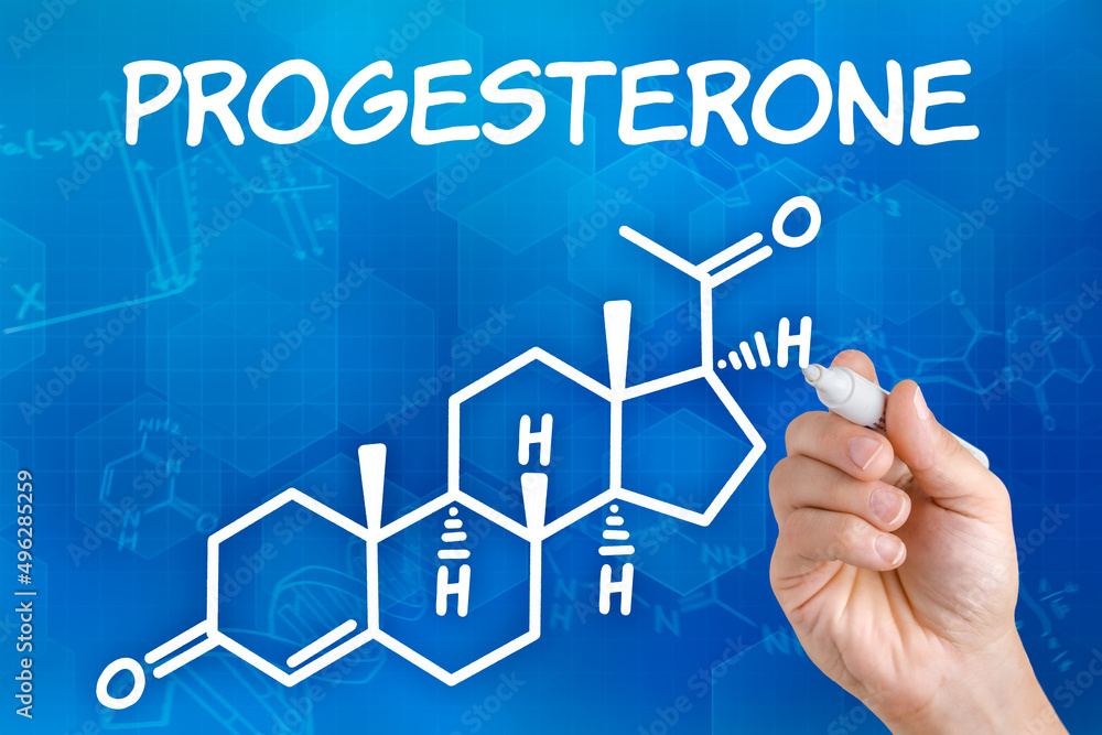 Hand with pen drawing the chemical formula of progesterone Hand with pen drawing the chemical formula of progesterone