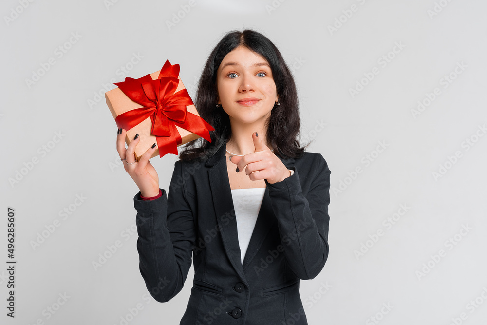 Curious cute brunette teenager girl in black blazer celebrating birthday, wonder whats inside b-day gift, shaking box and smiling happy, white background. Holidays, celebration and birthday concept Curious cute brunette teenager girl in black blazer celebrating birthday, wonder whats inside b-day gift, shaking box and smiling happy, white background. Holidays, celebration and birthday concept