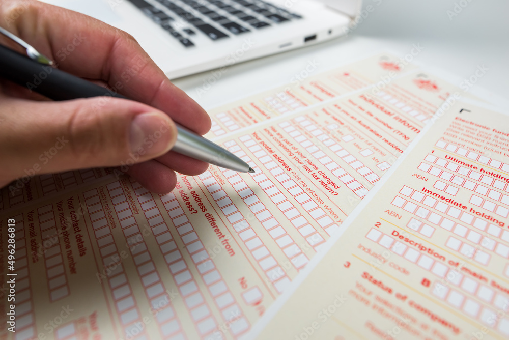 Close-up of a woman's hand filling out an Australian tax form Close-up of a woman's hand filling out an Australian tax form