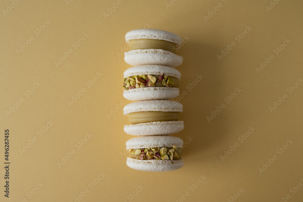 Four macaroons on a yellow background. The sweet dessert is isolated. Four macaroons on a yellow background. The sweet dessert is isolated.
