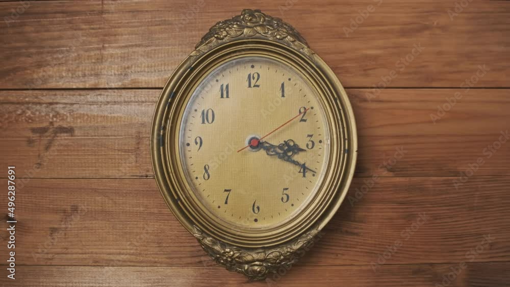 Old Retro Wall Clock with Moving Second Hand on Wooden Background. Vintage clock with a Yellow Scratched circular Dial. Old-fashioned antique clock. Arrow clock with second, minute, and hour hand. Old Retro Wall Clock with Moving Second Hand on Wooden Background. Vintage clock with a Yellow Scratched circular Dial. Old-fashioned antique clock. Arrow clock with second, minute, and hour hand.