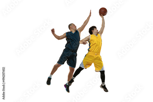 Dynamic portrait of two young basketball players jumping with ball isolated on white studio background. Motion, activity, sport concepts. © master1305