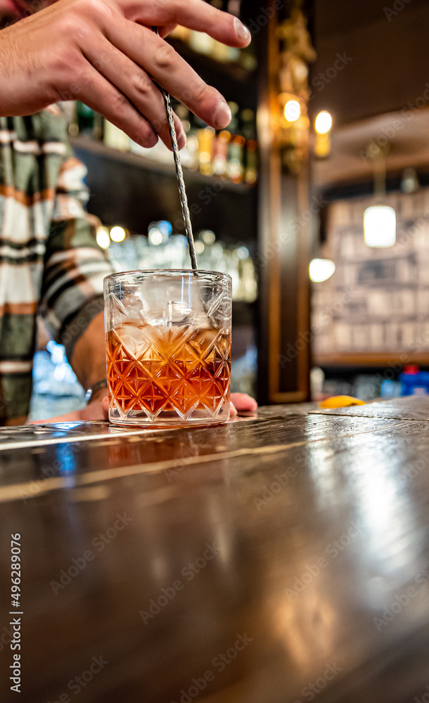 man hand bartender making glass negroni cocktail in bar