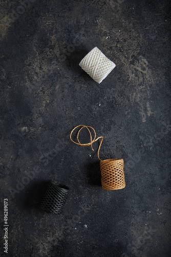 Skeins with threads. Dark moody black with grey concrete texture or background. With place for text and image